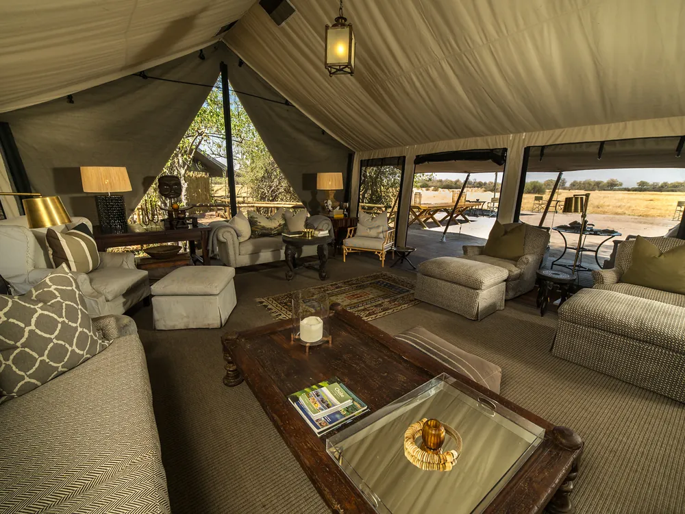 Comfortable seating inside an open safari camp lounge