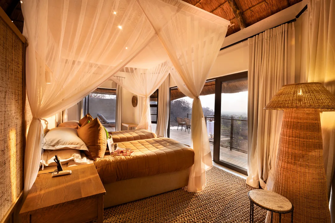 Safari lodge bedroom opening onto a deck in the Chobe region