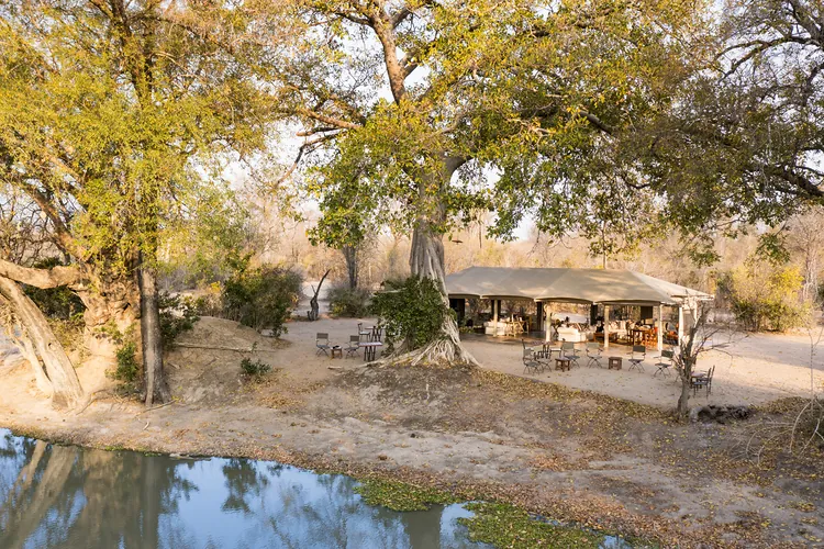 Safari camp beside a waterhole among trees in Mana Pools