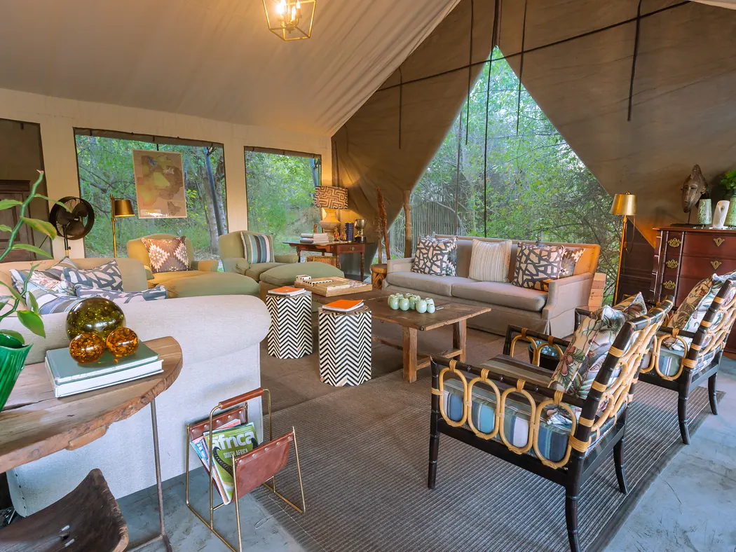 Safari camp lounge with comfortable seating and views of trees