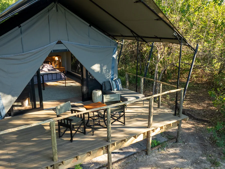Canvas safari tent with a bed and a private wooden deck